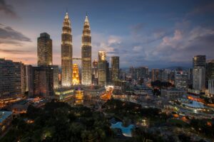 Stunning Kuala Lumpur skyline featuring the illuminated Petronas Towers at twilight.