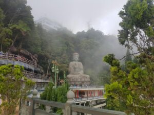 Discover the serene Buddha statue amidst misty lush greenery in Genting Highlands, Malaysia.